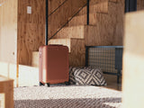 スーツケース「moln」のSmall+サイズのテラコッタ色がデザイナーズホテル「MEMU EARTH HOTEL」に置かれている画像