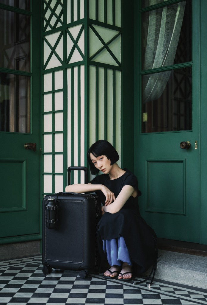 A woman sitting with Grain by a green door